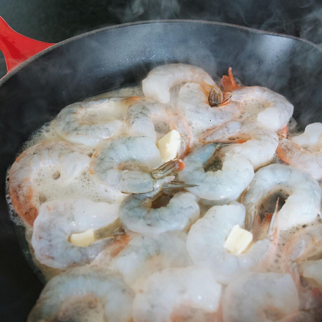 Jumbo Tiger Prawns being fried in a pan with butter.
