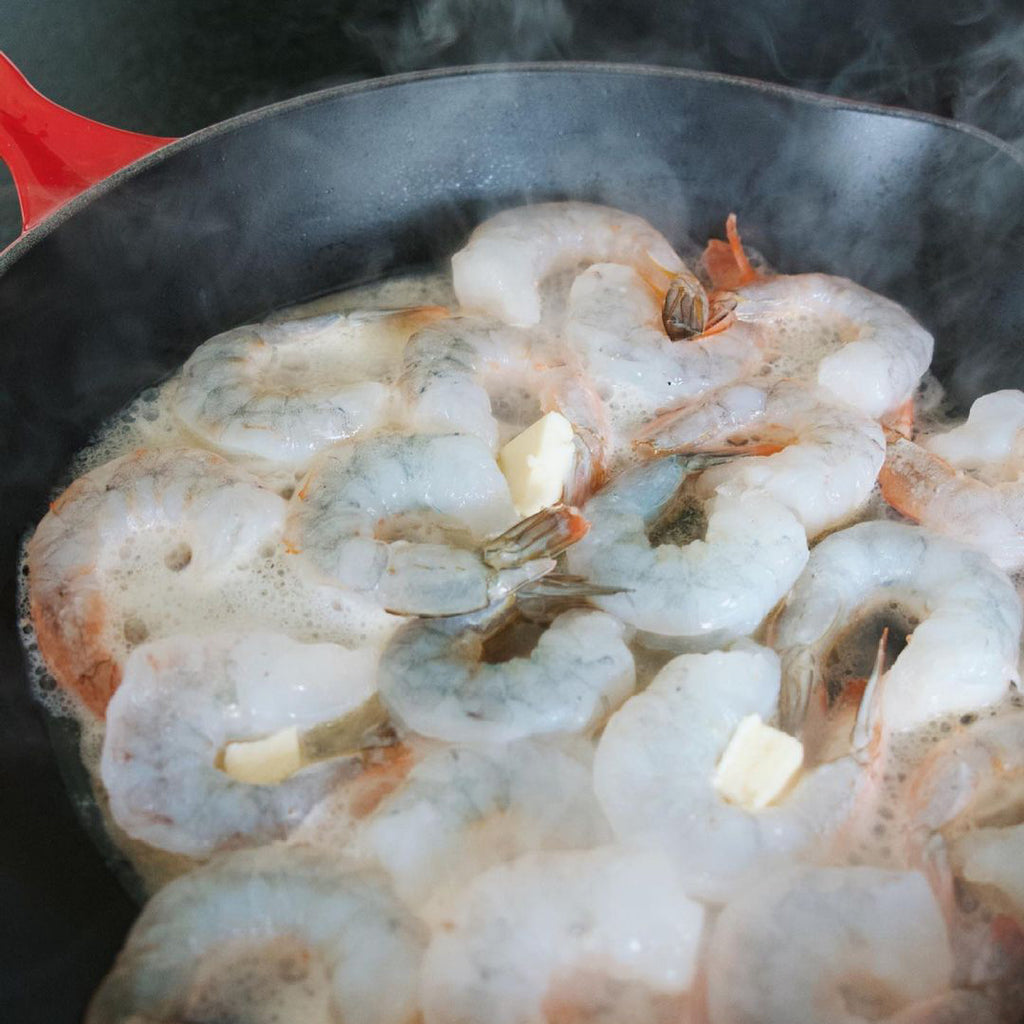 Jumbo Tiger Prawns being fried in a pan with butter.