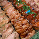 Maple Bourbon chicken breasts garnished in parsley next to different flavoured chicken breasts.