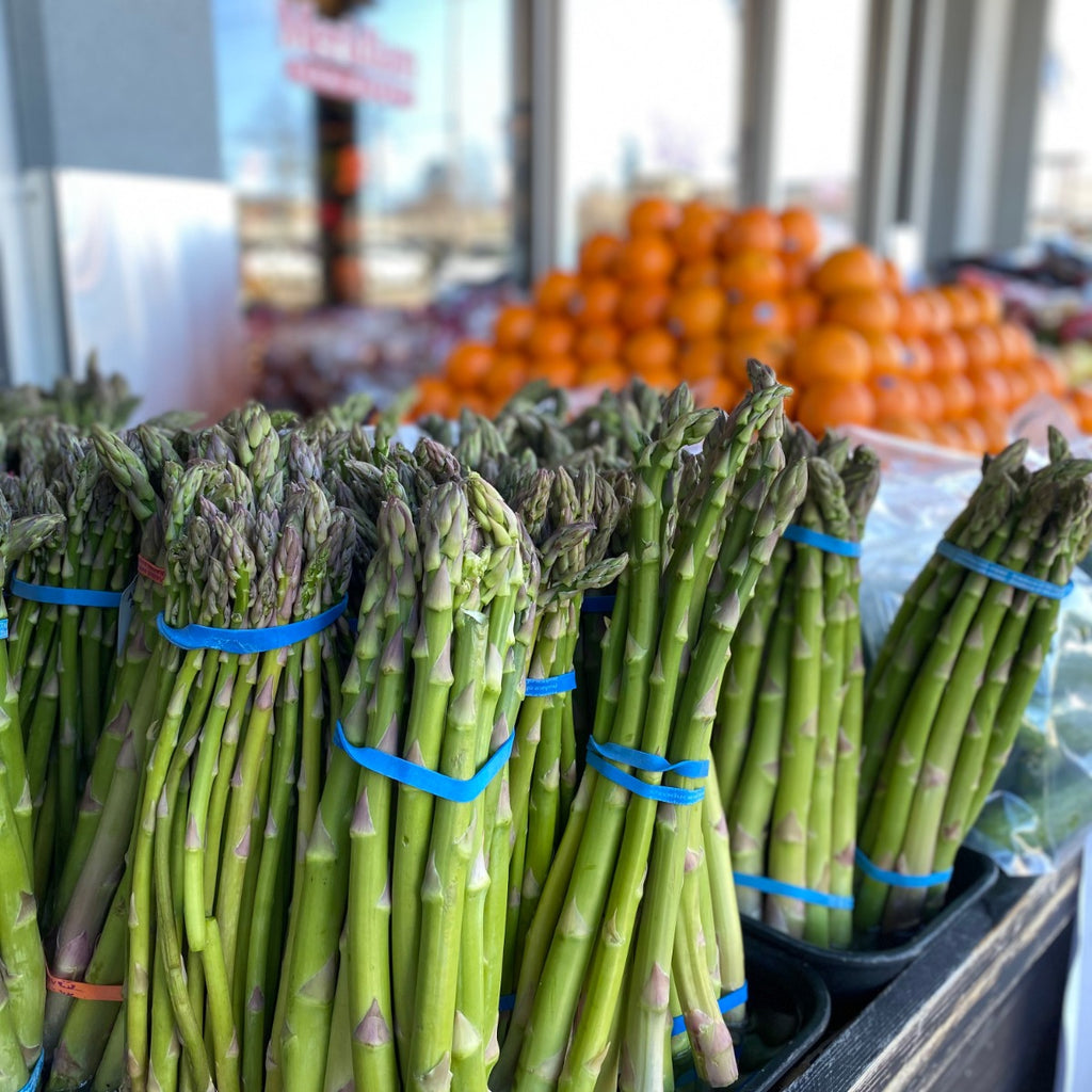 Bundles of fresh green asparagus out on display in front of Meridian Farm Market.