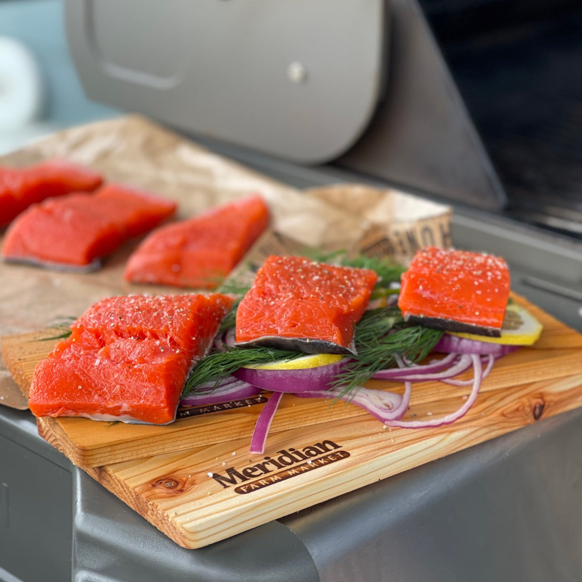 Wild salmon fillets seasoned with salt and pepper on top of dill