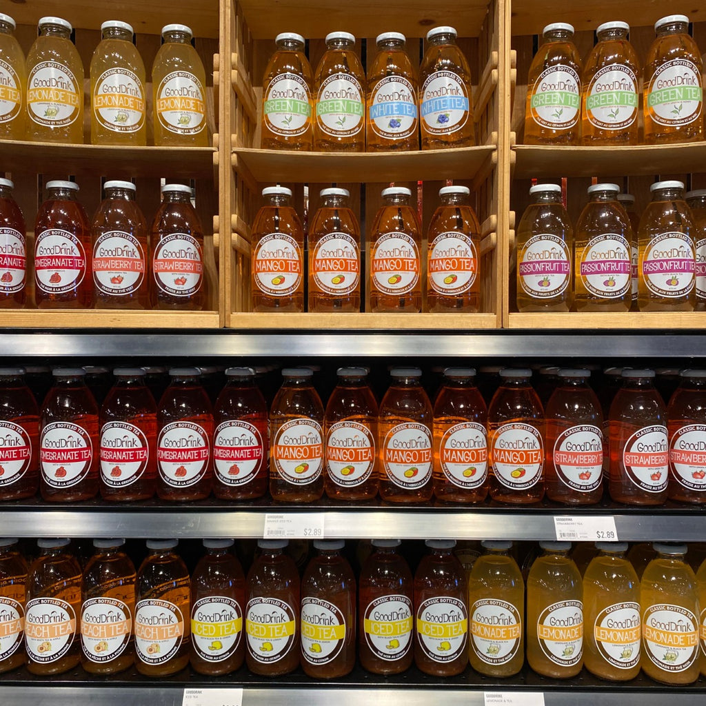 Gooddrink Iced Tea with Lemon displayed in wooden crates next to an assortment of Gooddrink Tea.