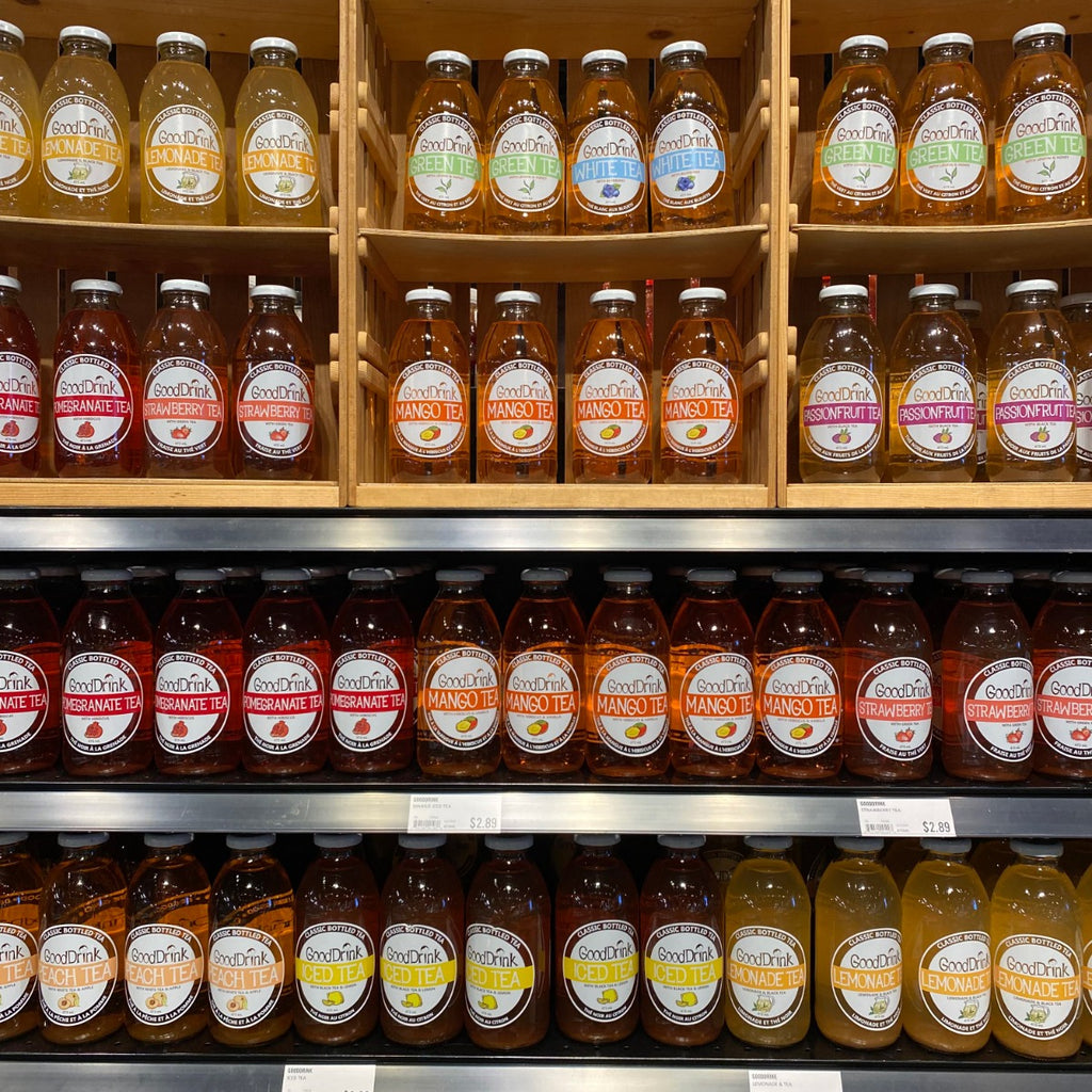 Gooddrink Mango Tea with Hibiscus and Vanilla in wooden crates next to an assortment of Gooddrink Tea. 