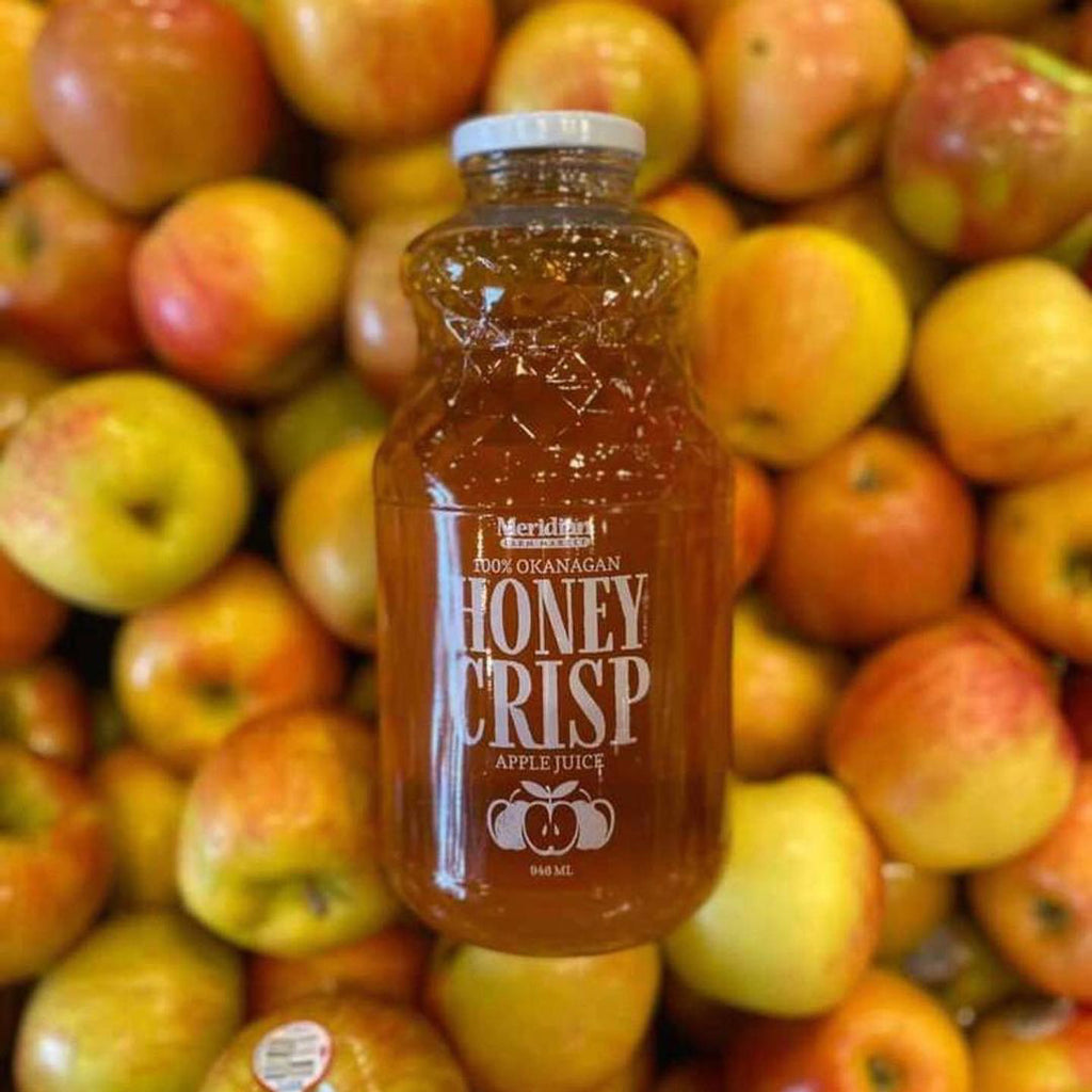 Meridian Farm Market Honey Crisp Apple Juice 946 ml placed on top of honey crisp apples.