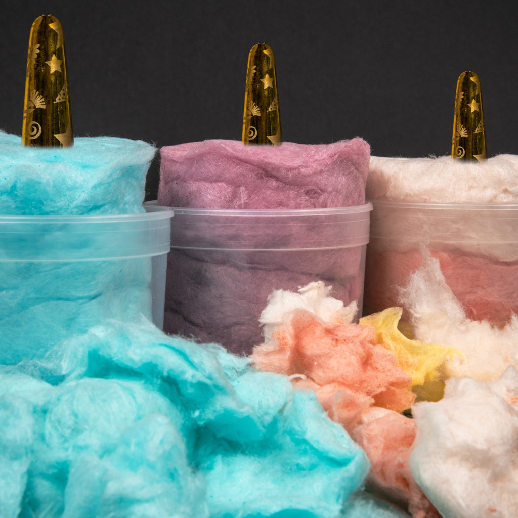 Blue Raspberry, Purple and Banana Split flavoured cotton candy bursting out of a plastic container.