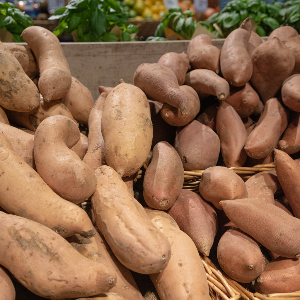 Yams and Sweet Potatoes in wicker baskets on display in a Meridian Farm Market. 