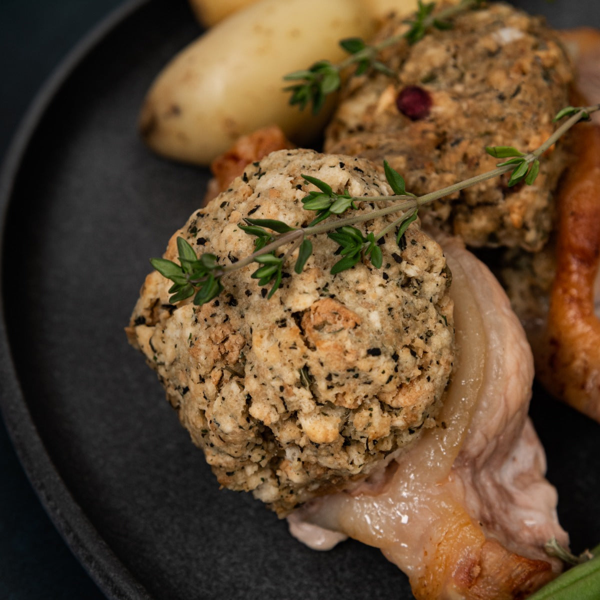 Cooked garden herb and cranberry herb stuffed porkchops garnished with thyme.